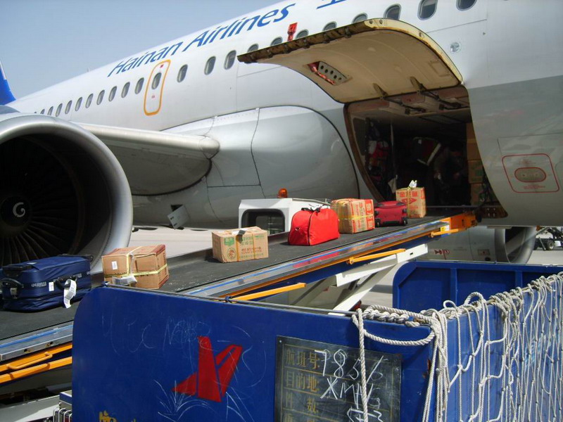 为空客A319前货舱勤务的带式货物传送车，我们还能看到蓝色的行李拖斗车