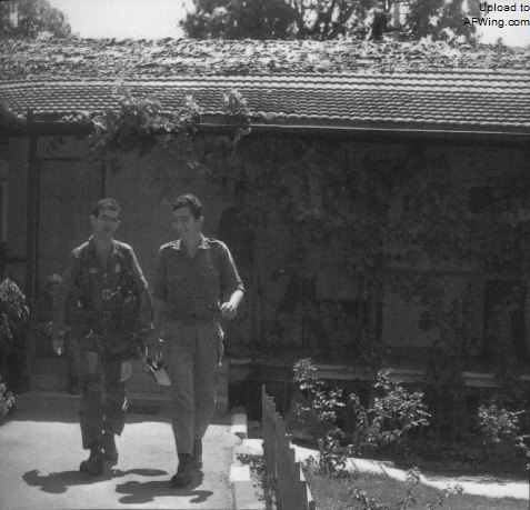 1982年6月10日，阿米.卢斯蒂格（左）驾驶F-16A雀鹰138击落一架米格-23后在拉马特.戴维基地里交谈，房顶上被铺上了伪装网